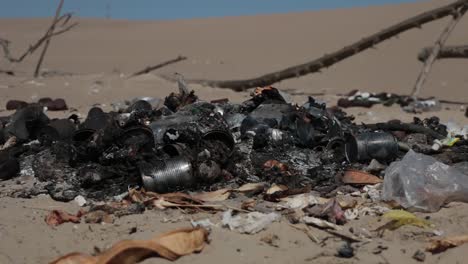 burned household garbage in sand dunes landscape