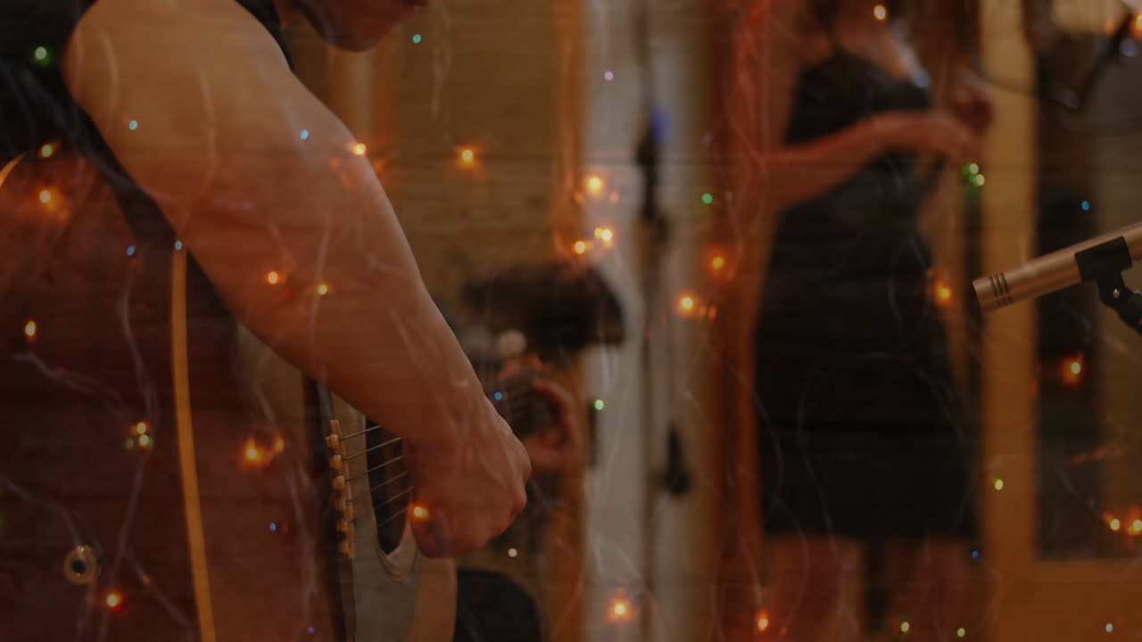 Punti luminosi di luce sullo sfondo di un uomo che suona la chitarra