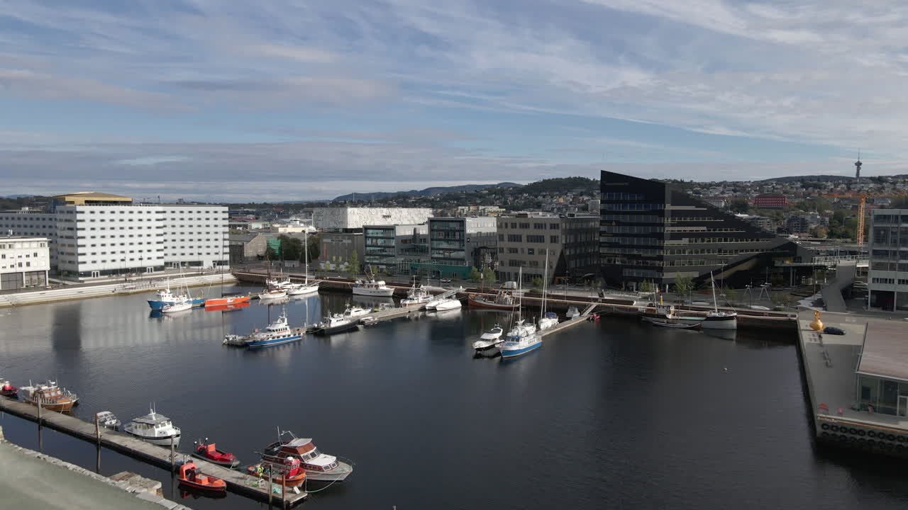 Boote und Yachten im Hafen von Trondheim, Norwegen, mit modernen Gebäuden im Hintergrund.