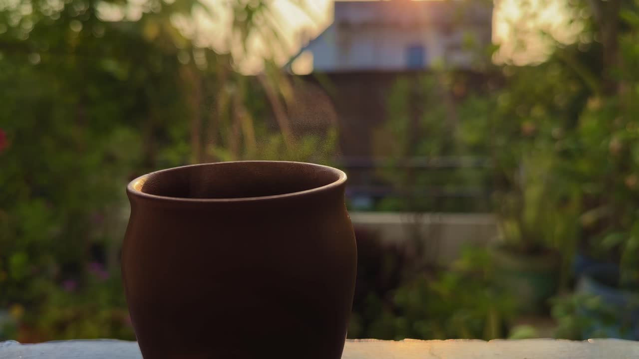 A steaming cup of tea in a clay kullad glows softly in the golden morning light — capturing the warmth, aroma, and simplicity of traditional Indian tea culture