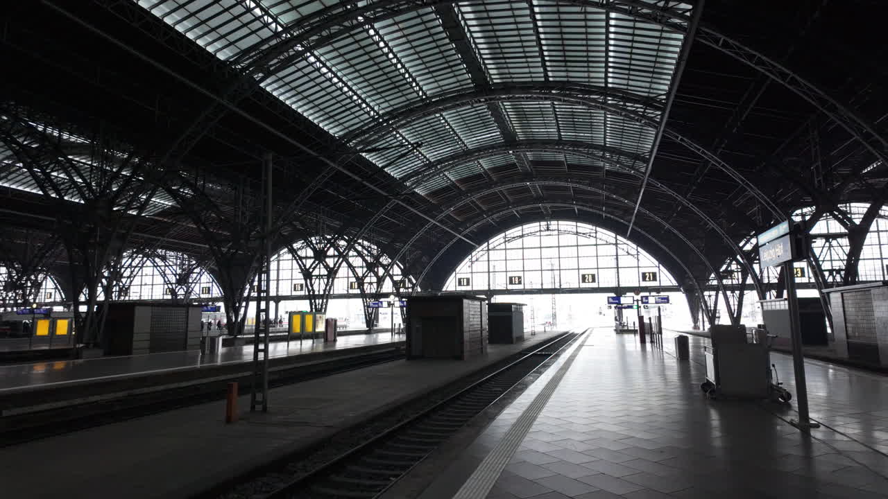 Oversigtsbillede af Leipzigs offentlige transportknudepunkt med jernbanestation, perroner og tog i dagslys.
