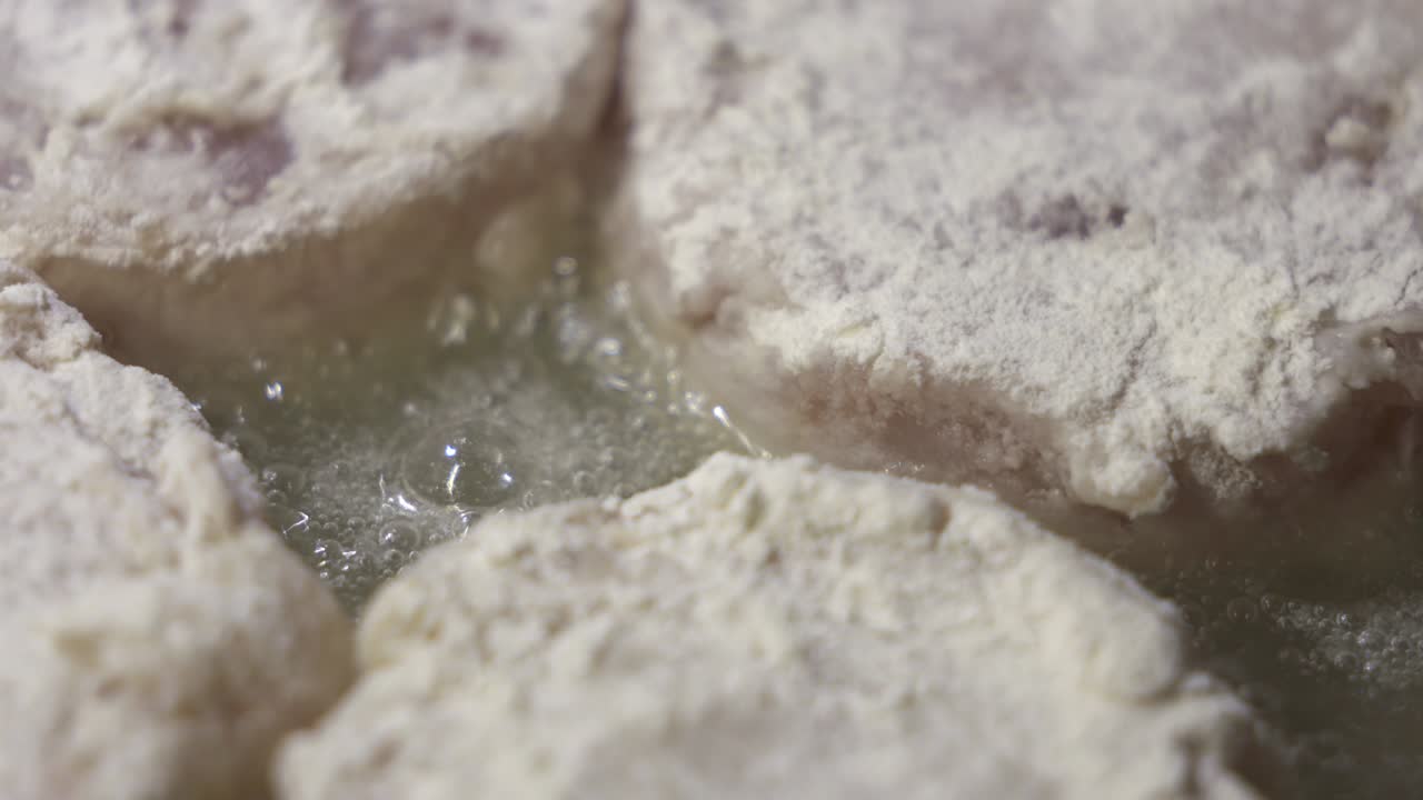 집에서 만든 긴 생선 햄버거 패티. 뜨거운 기름으로 생선 패티를 는 것