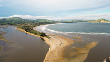 aerial shot of the bay of huriawa historic site on a foggy day, a peninsula located in new zealand