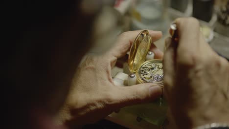 a man is repairing a watch on the workbench