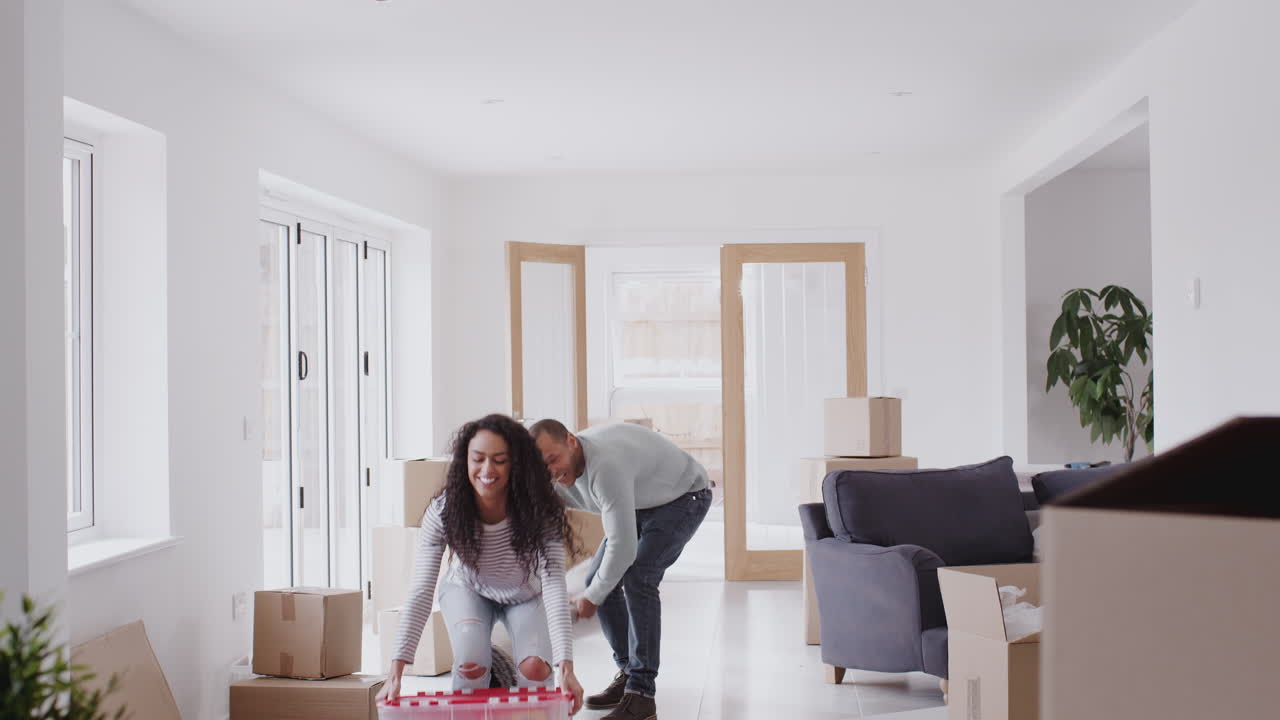 Loving Couple Surrounded By Boxes Hug As They Move Into New Home Together