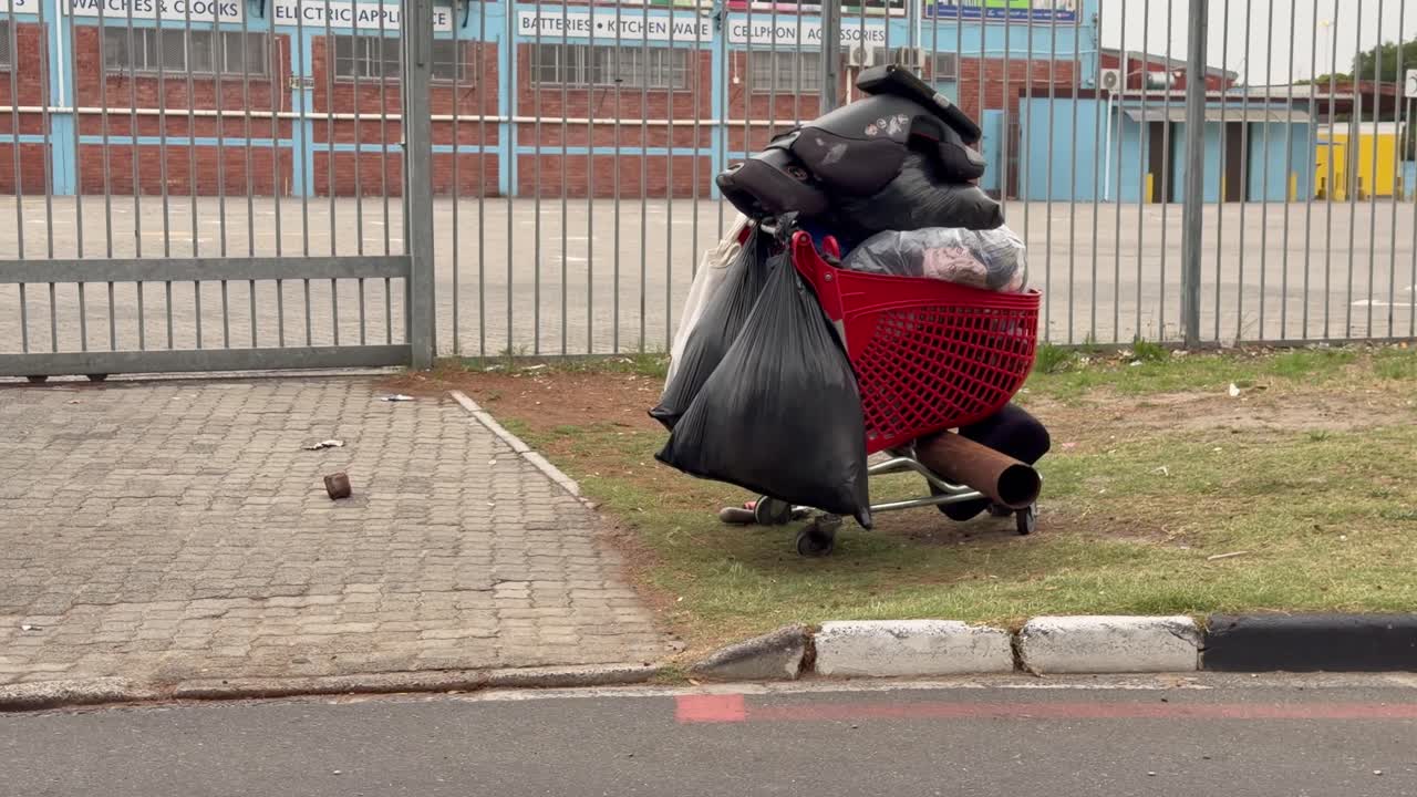A homeless person’s trolley parks on the side of the street in Cape Town