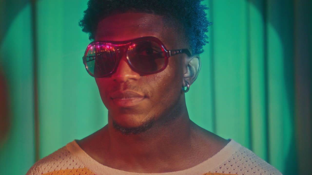 Portrait of African American Man in Retro Sunglasses under Colorful Lights