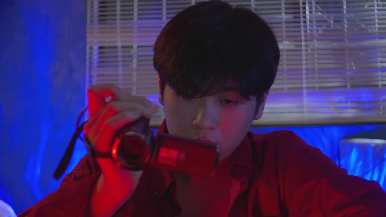 아시아 남성이 술을 마시면서 그의 레트로 빈티지 레코드 카메라 플레이어의 디스플레이를보고 기억을 잊고 가이 부러진 개념