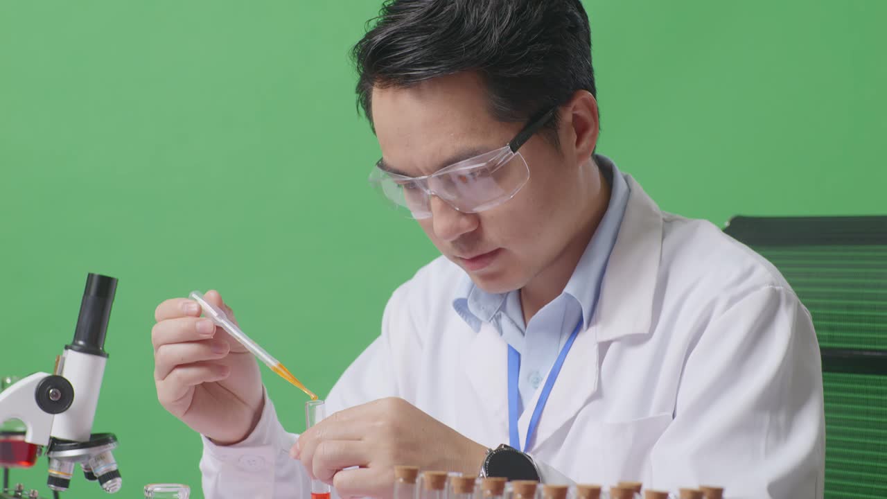 Close Up Of Side View Of Asian Man Scientist Making Experiment With Test Tube And Screaming Goal Celebrating While Working On The Table With Microscope In The Green Screen Background Laboratory