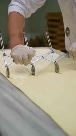 the pastry chef cuts the pastry sheet with a round knife