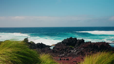 Slow-motion-static-shot-of-rough-ocean-waves-crushing-against-the-volcanic-rocky-coastline
