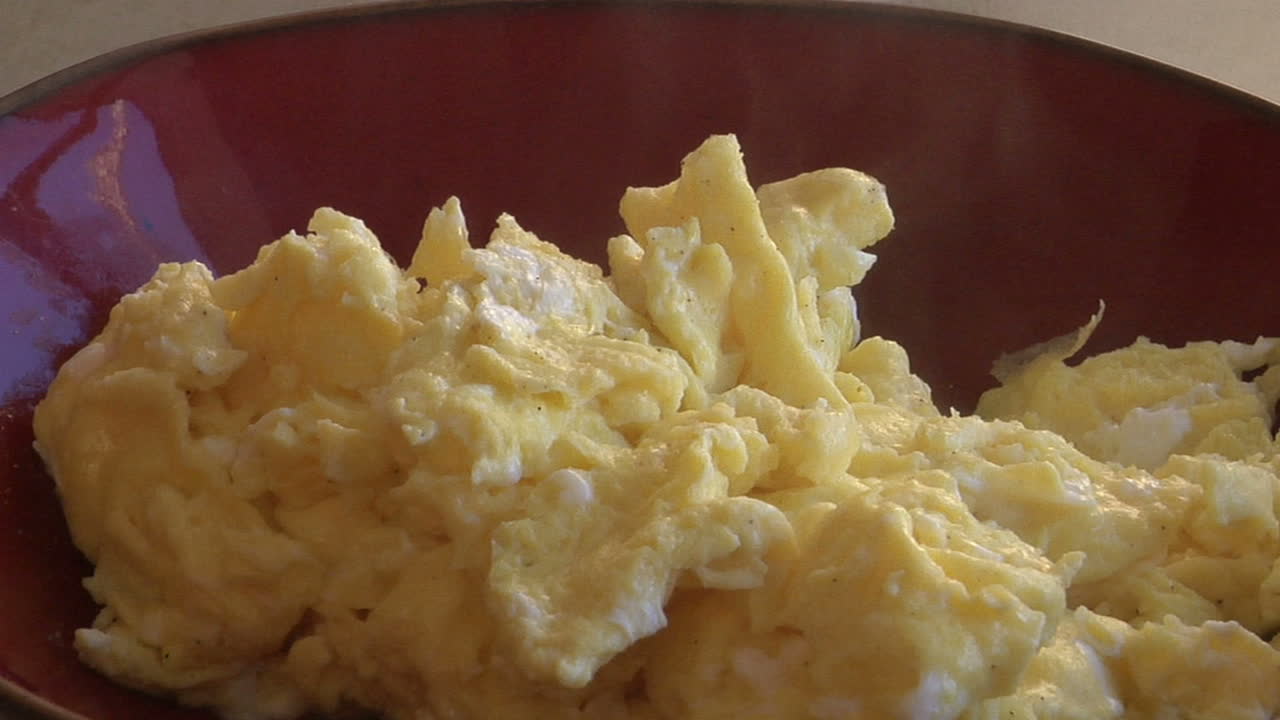 un movimiento lento en un tazón de humeantes huevos revueltos