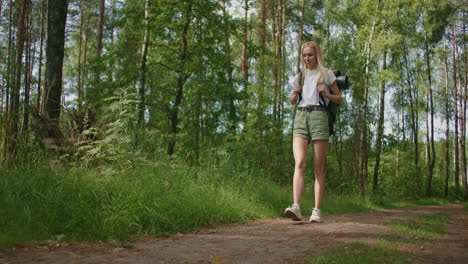 general plan: traveling happy caucasian woman with backpack walking on path the tropical forest