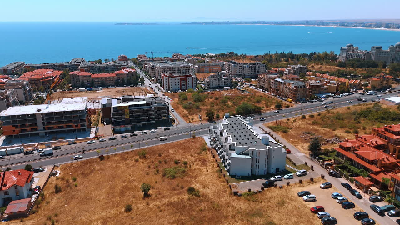 Coastal neighborhood with residential architecture near the sea. Aerial drone view of a seaside neighborhood with apartment buildings and clear blue water