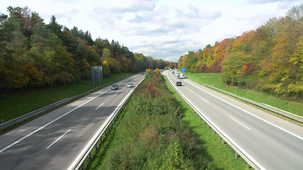 가을 시즌의 다채로운 나무로 둘러싸인 운전 자동차가 있는 독일 아우토반의 전망
