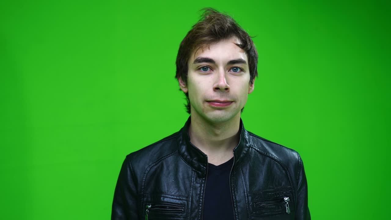 retrato de un hombre blanco con chaqueta de cuero mirando a la cámara en la pantalla verde.