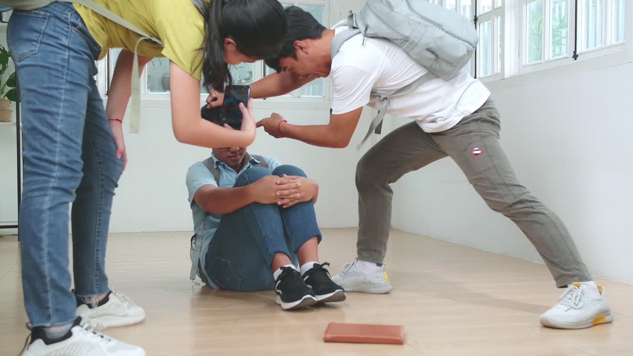 Young Asian Students Bullying Caucasian Boy In Glasses And Record Video On Mobile Phone
