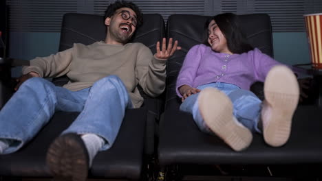 front view of a couple sitting in a vip cinema.