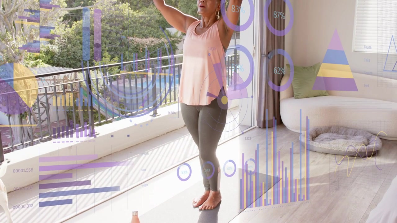 Senior woman starting feet together doing yoga by balcony with charts over mat showing fitness data