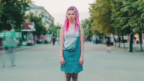 woman in denim overalls with pink dreadlocks