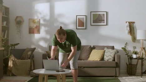 blond guy watching sport video on the laptop