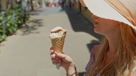 turista femenina con sombrero de sol, disfrutando del helado local en el cono crujiente, tenerife