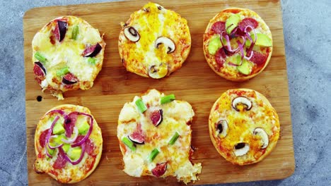 various pizzas on wooden board