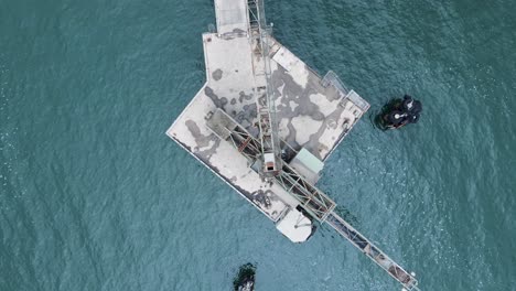 revealing drone view of an industrial structure protruding from the ocean located on an environmentally fragile part of coastline