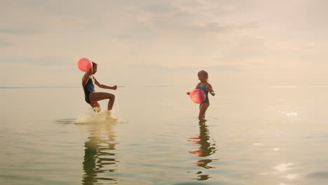 two sisters playing in the water - splash each other laughing