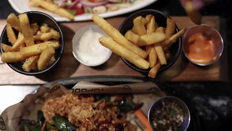 fries and chicken wings with dipping sauces