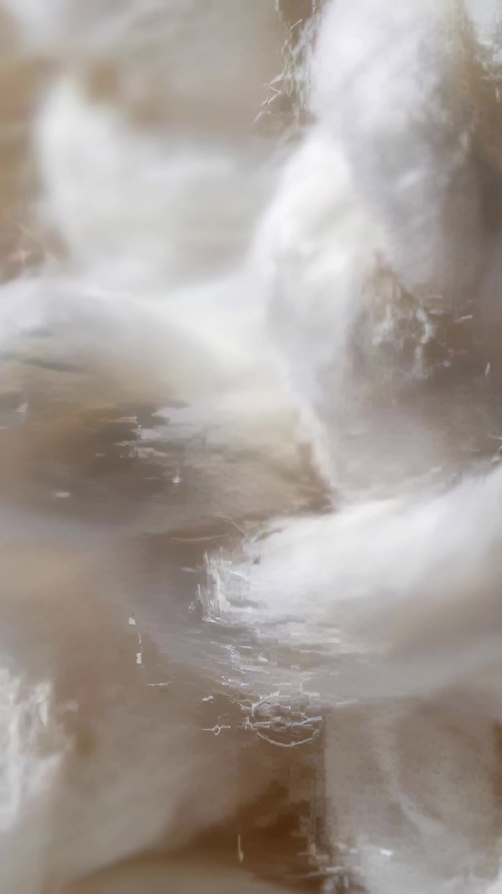 Vertical video: Panning camera revealing white cotton braid knot on tan surface, showing tufts