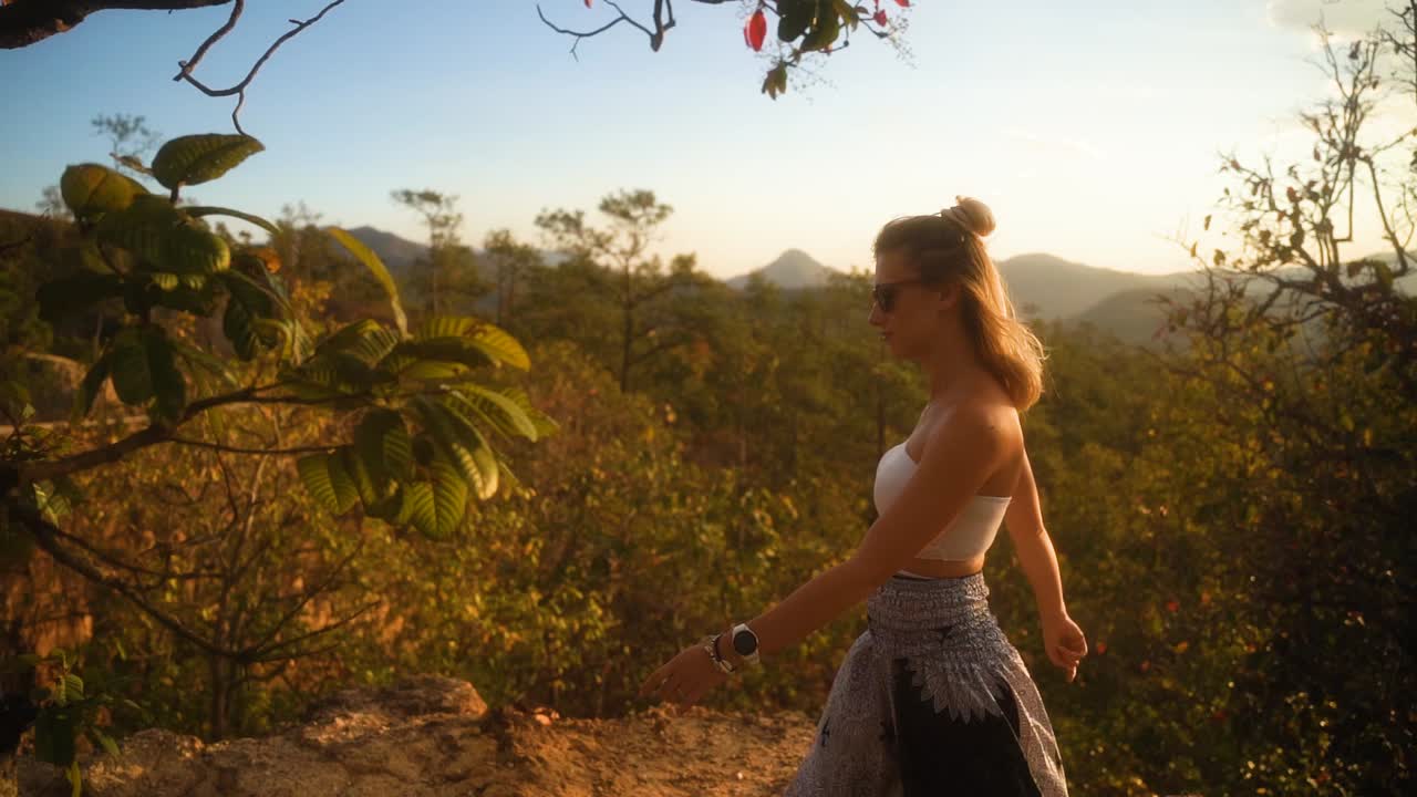 hermosa mujer rubia europea vestida de verano está caminando disfrutando de la hermosa naturaleza verde del cañón pai durante la hora dorada en tailandia