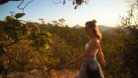 beautiful blond european woman in summer clothes is walking enjoying the beautiful green nature of pai canyon during golden hour in thailand