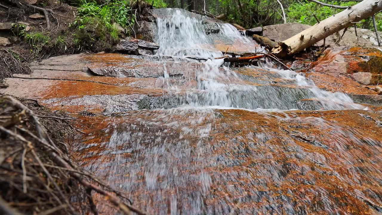 catarata en cascada por una roca de un pequeño arroyo filmado en las montañas rocosas de colorado en el parque estatal de staunton