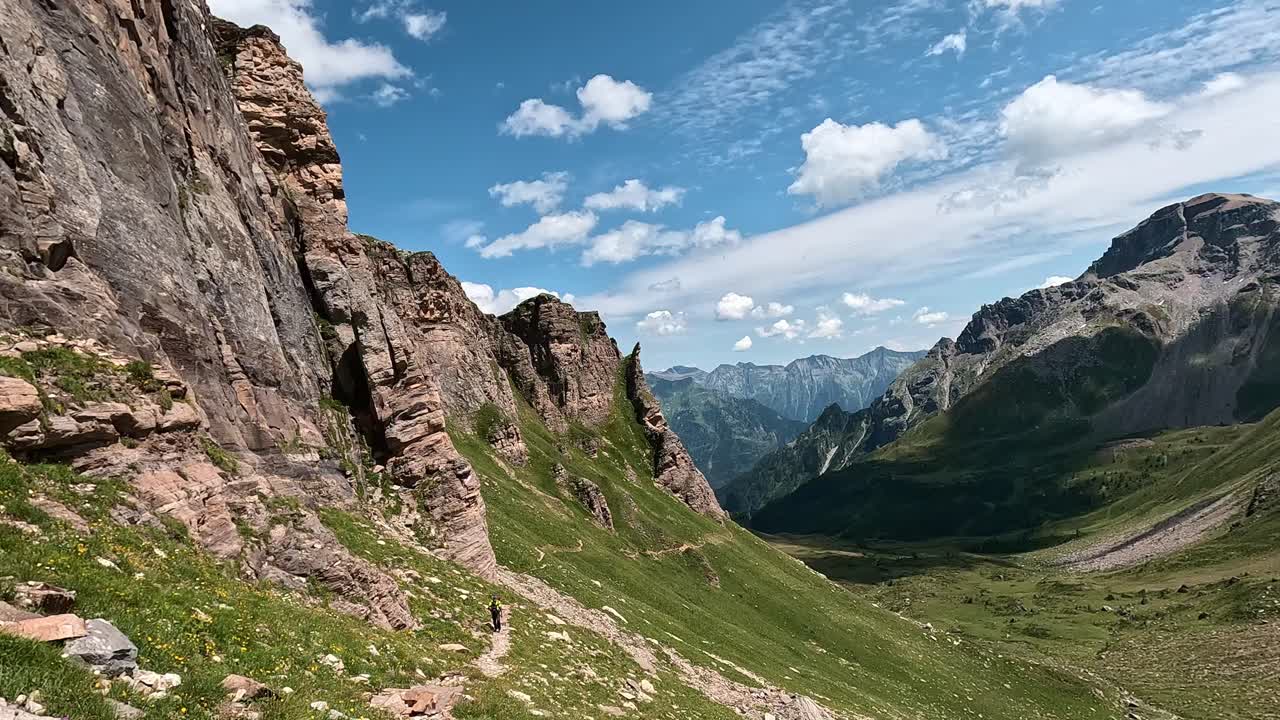 Jagged rocky ridge and vast alpine valley beneath a bright blue sky in the Alpe Devero region, Italian Alps
