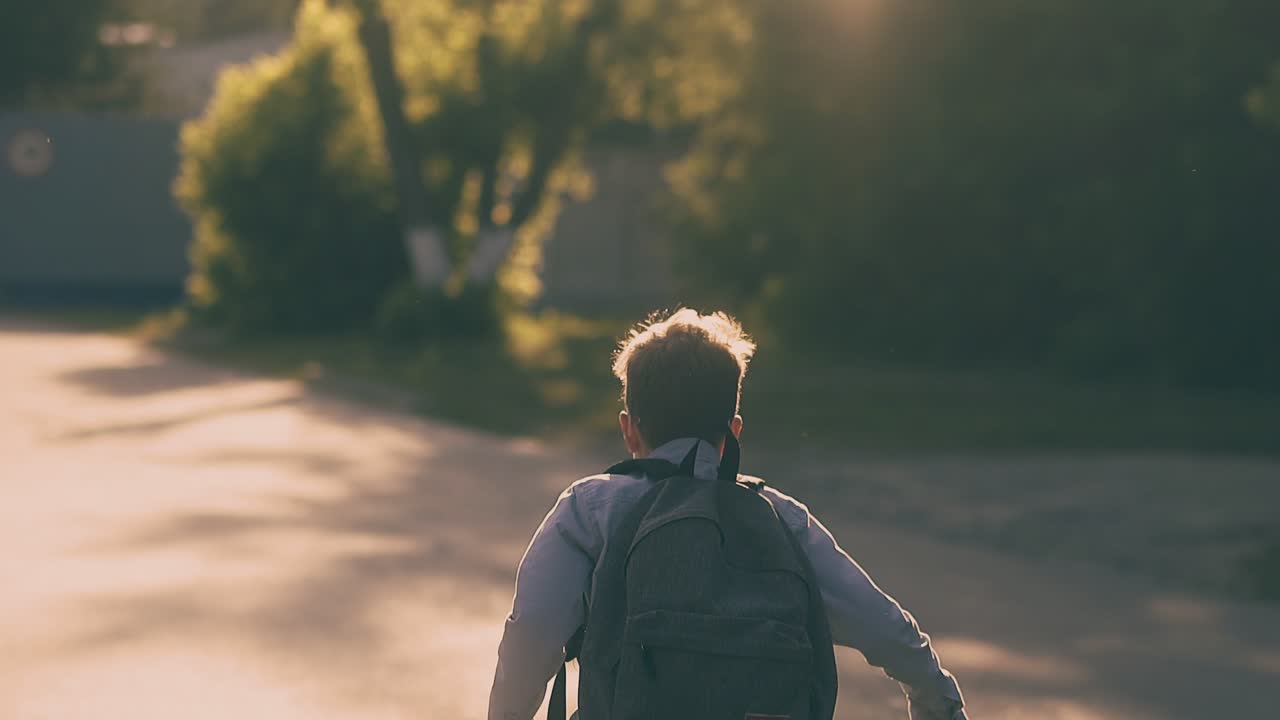 어린 학생 이 아스팔트 도로 를 따라 달려서 종이 시트를 던진다