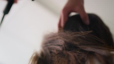 Handheld-view-of-woman-has-drying-hair-at-the-hairdresser