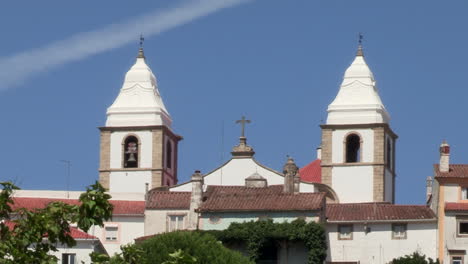 the two white towers of the church of santa maria da devesa in the middle at the top of the village