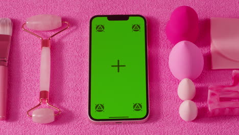 pink beauty flat lay with green screen phone
