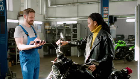 mechanic and rider talking at the garage