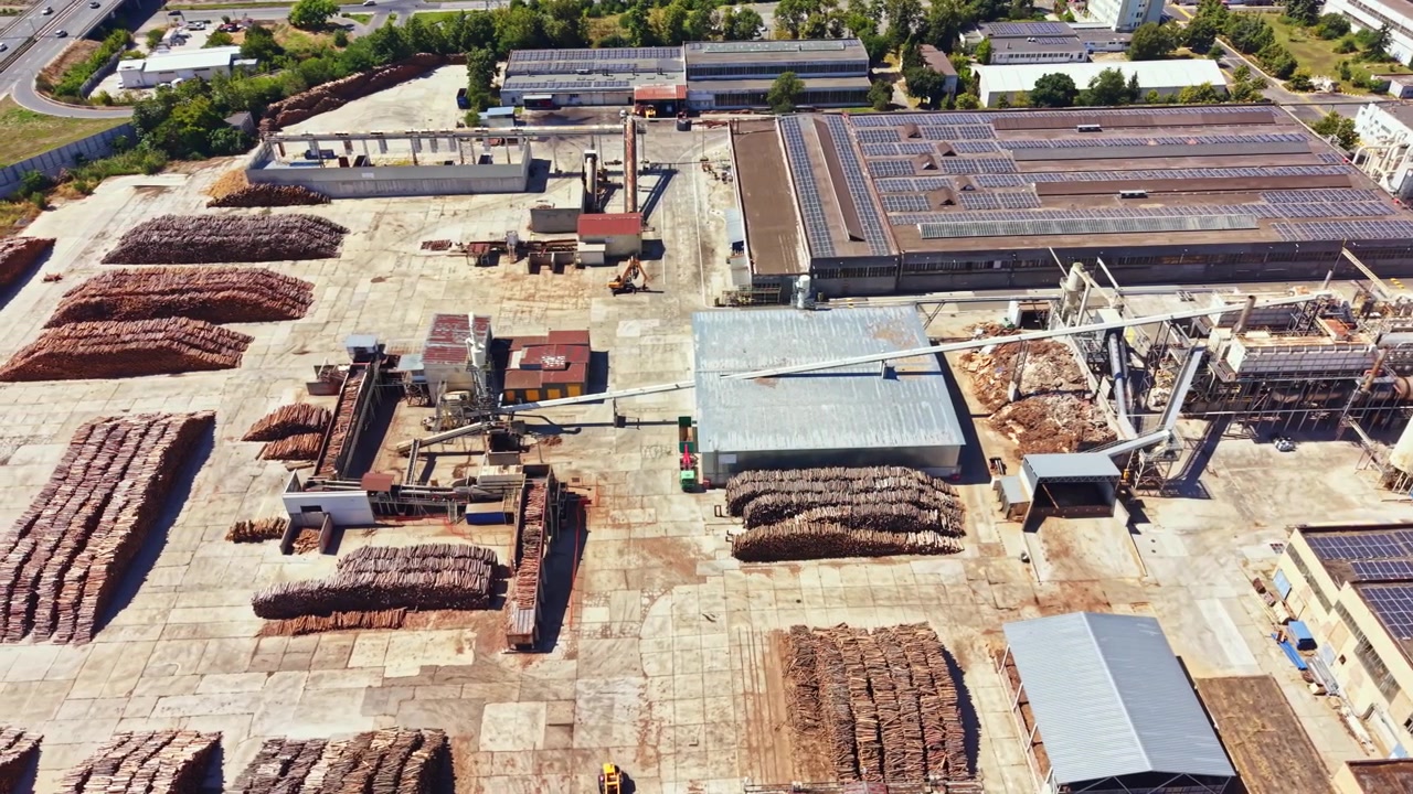 Cantiere edile con macchinari e pile di materiali in una vasta area industriale durante il giorno
