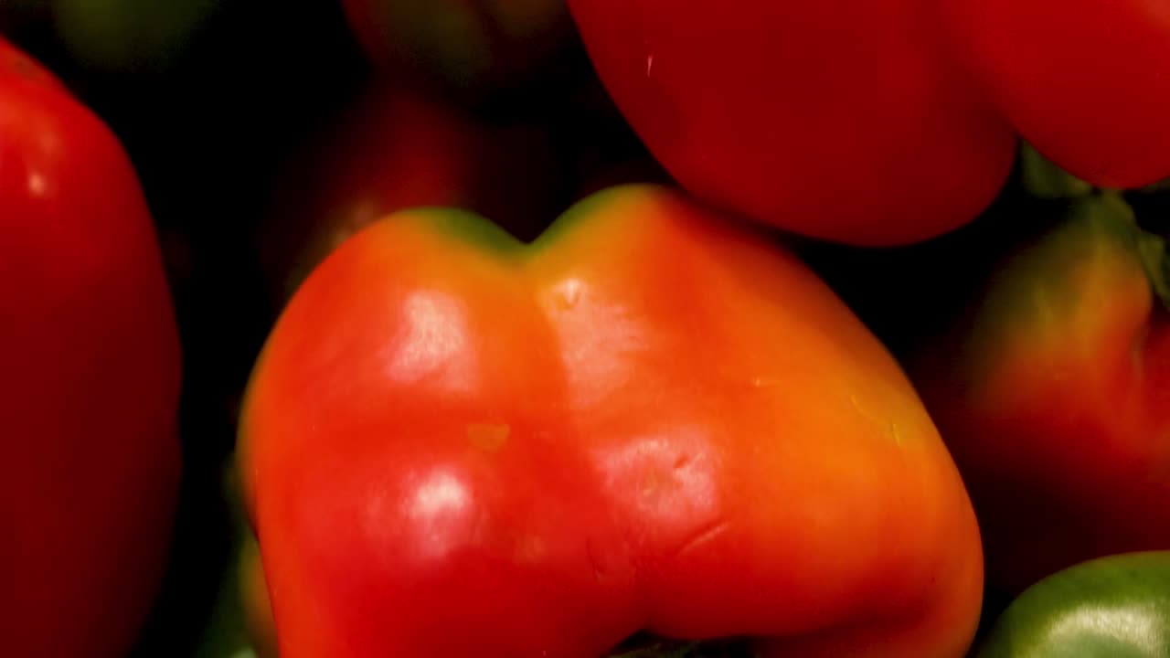 Una fitta disposizione di peperoni freschi rossi e verdi in una bancarella di mercato locale.