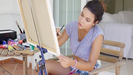 artista femenina atractiva trabajando en un lienzo