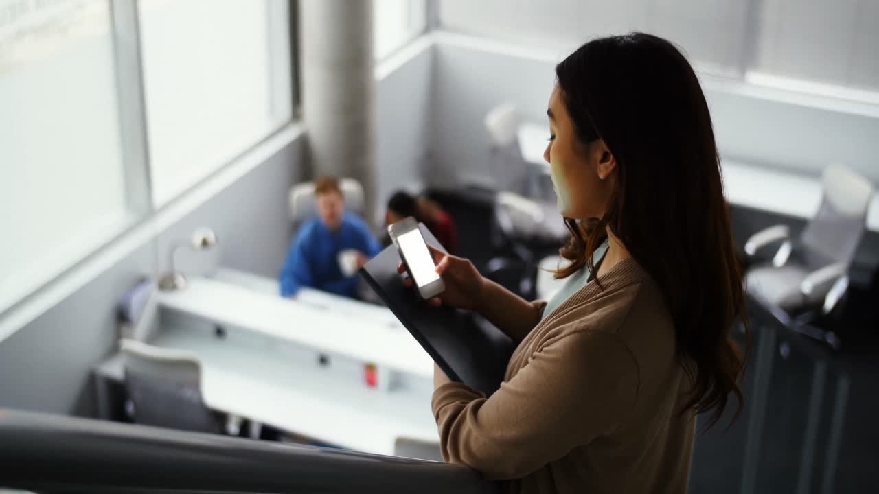 Female executive using mobile phone