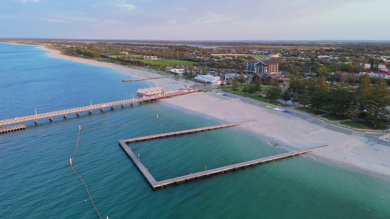 Sunset over Busselton Jetty ocean pool as drone pans slowly around