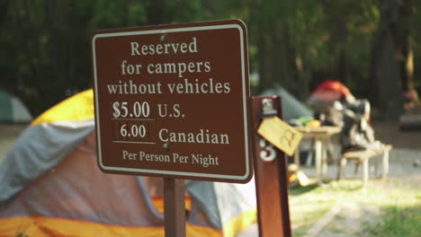 view of a reserved area signboard indicating the amount to be paid by us citizen and canadian citizen for camping in glacier np campground and creek