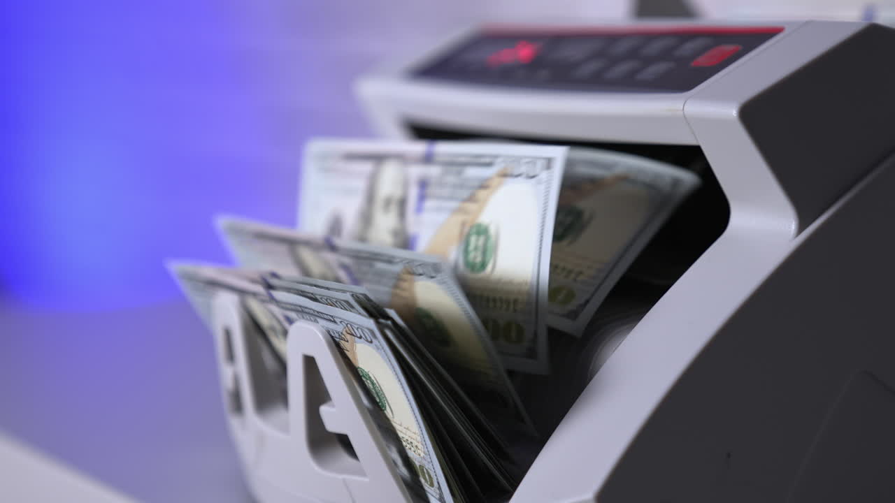 Pengeutstyr for beregning av papirpenger. Automatisk mekanisme for finansielle bankoperasjoner. Valutaveksling av hundre USD. Nærbilde av valutatellermaskin som teller dollarsetler
