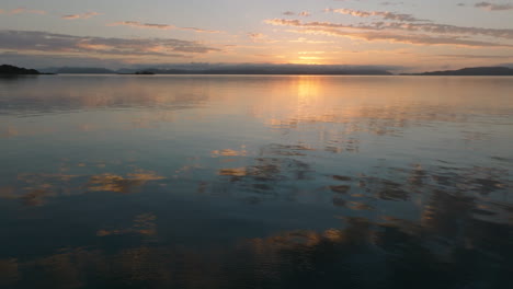 stationary shot of the beautiful coloured sky and clouds reflecting in the still ocean waters of the whitsunday islands during sunrise