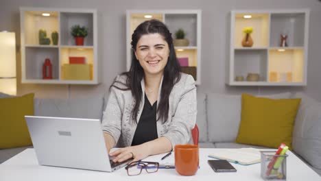 home office worker woman smiles at camera.