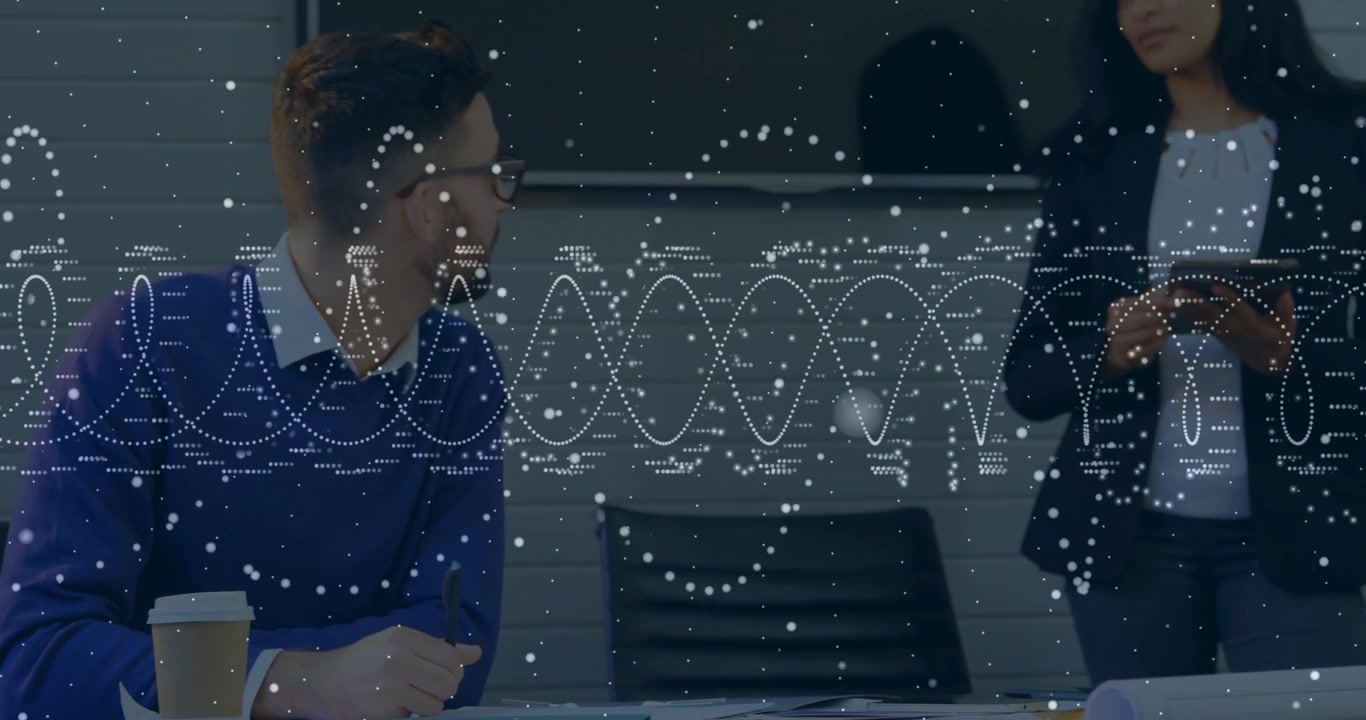 Seated man reviewing documents while female colleague swiping tablet projecting graphs for business